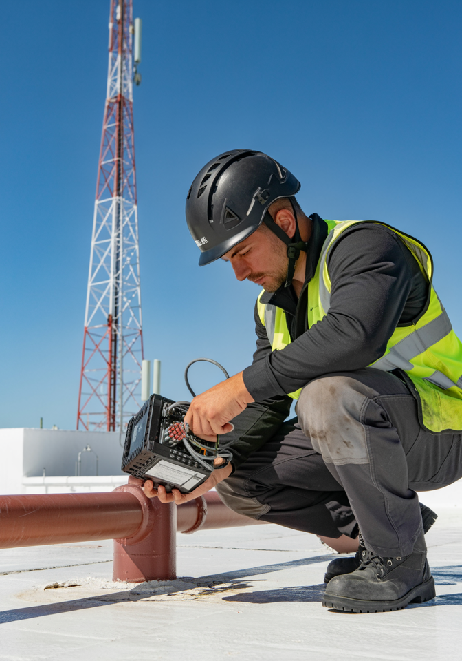 Worker wearing custom branded safety gear on a cellular tower
